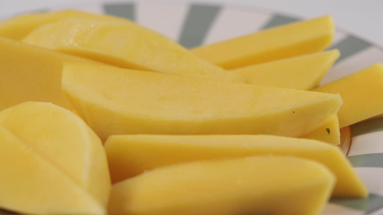 Zbliżenie świeżo pokrojonego żółtego mango na talerzu