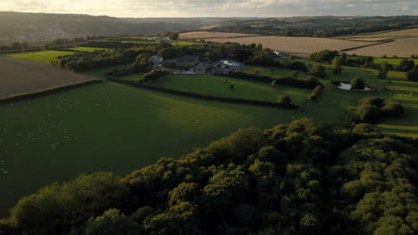 Drone-Vuela-Hacia-Una-Granja-En-Cornwall,-Reino-Unido-Al-Atardecer