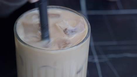una mujer bebiendo café helado.