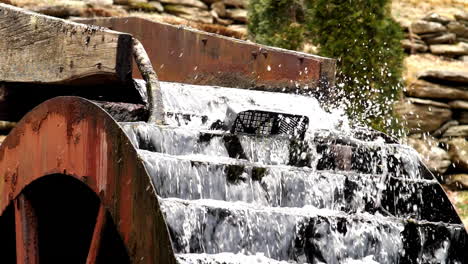 agua que fluye en cámara lenta disparada a 180 fps sobre una vieja rueda de agua