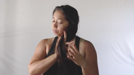 Latin-adult-woman-combs-her-long-black-hair-with-comb-after-bathing