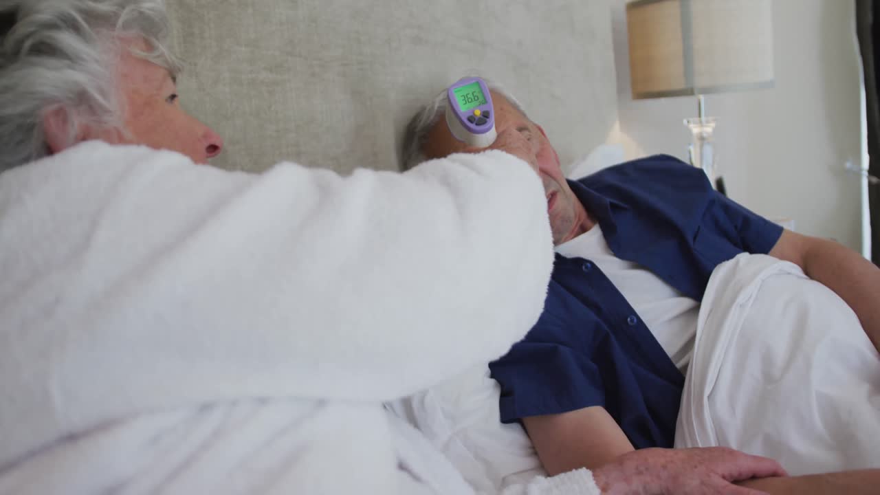 디지털 온도계로 남편의 온도를 측정하는 고위 백인 여성 36.6de