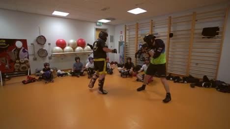 slow motion  video of a young boxer fighting in a training room. boxer trainer with children.