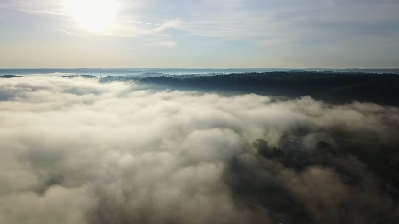panorámica aérea lenta de grandes tierras de cultivo verdes y nubes bajas sentadas en medio de los cielos azules de kentucky