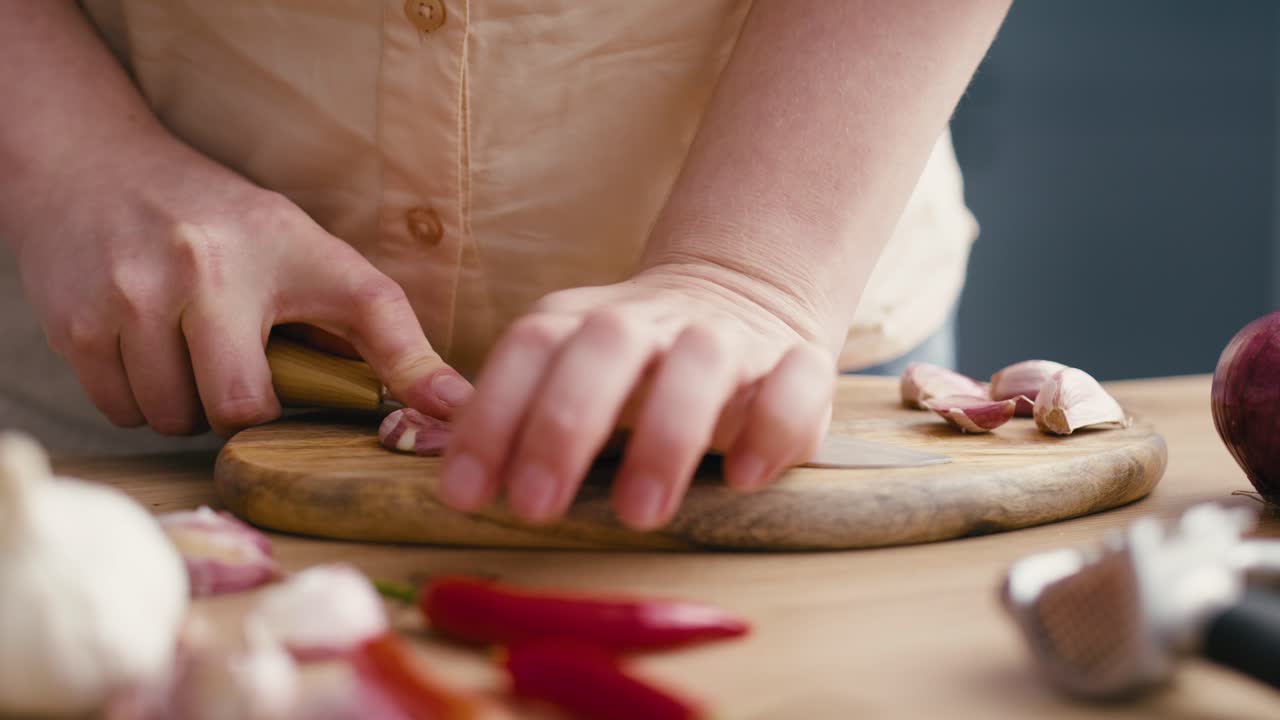 mujer usando ajo fresco en la cocina.