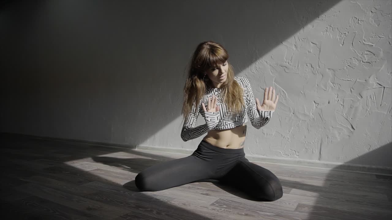 mujer practicando danza o postura de yoga en un estudio