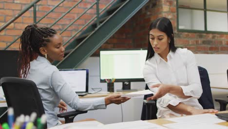 Happy-diverse-female-business-colleagues-discussing-work-at-office