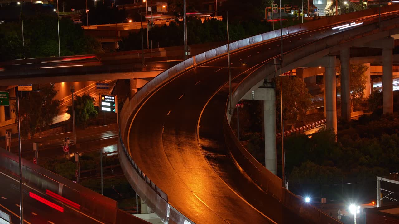 Nighttime time-lapse shot capturing traffic on Brisbane inner city bypass on a stormy and rainy night.