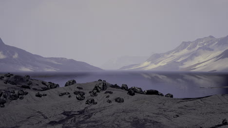 Foggy coastal landscape with distant mountains and rocky shoreline