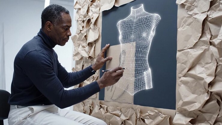 An artist skillfully sketches a wireframe design of a mannequin on brown paper, showcasing creativity and precision in a studio filled with textured materials.