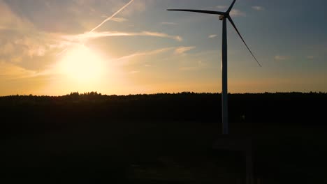 Große-Windkraftanlagen-Mit-Rotorblättern-Im-Feld,-Luftaufnahme,-Leuchtend-Orangefarbener-Sonnenuntergang,-Blauer-Himmel,-Windpark,-Zeitlupe,-Drohnendrehung