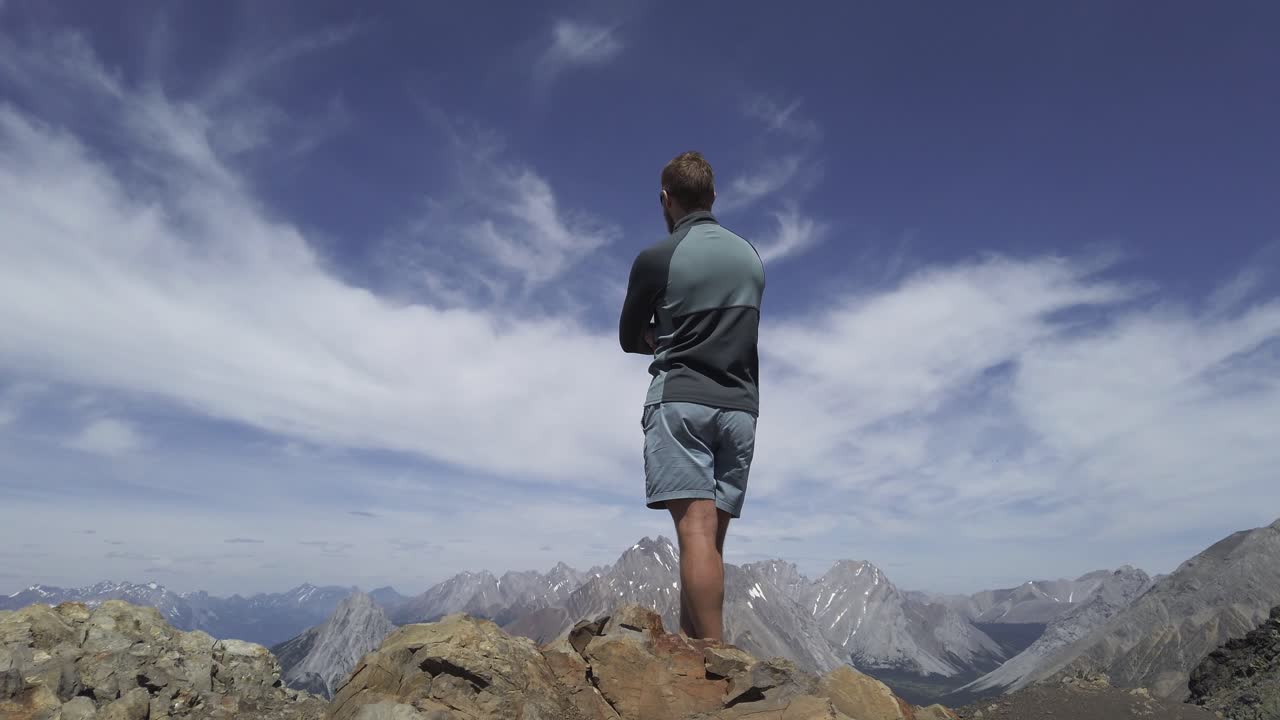 excursionista mirando la vista desde el pico de las montañas rocosas kananaskis alberta canada