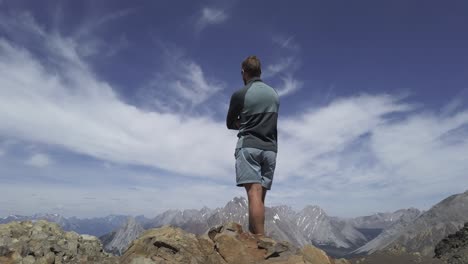 Hiker-looking-at-the-view-from-peak-of-mountain-Rockies-Kananaskis-Alberta-Canada