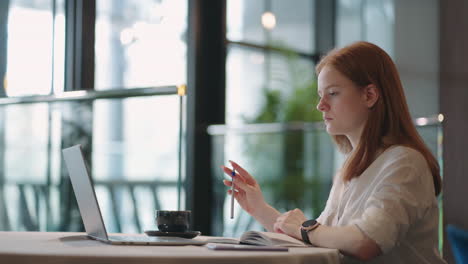 Una-Joven-Está-Aprendiendo-Idiomas-Extranjeros-En-Línea-Escuchando-Conferencias-En-Una-Computadora-Portátil-Y-Tomando-Notas-En-Un-Cuaderno