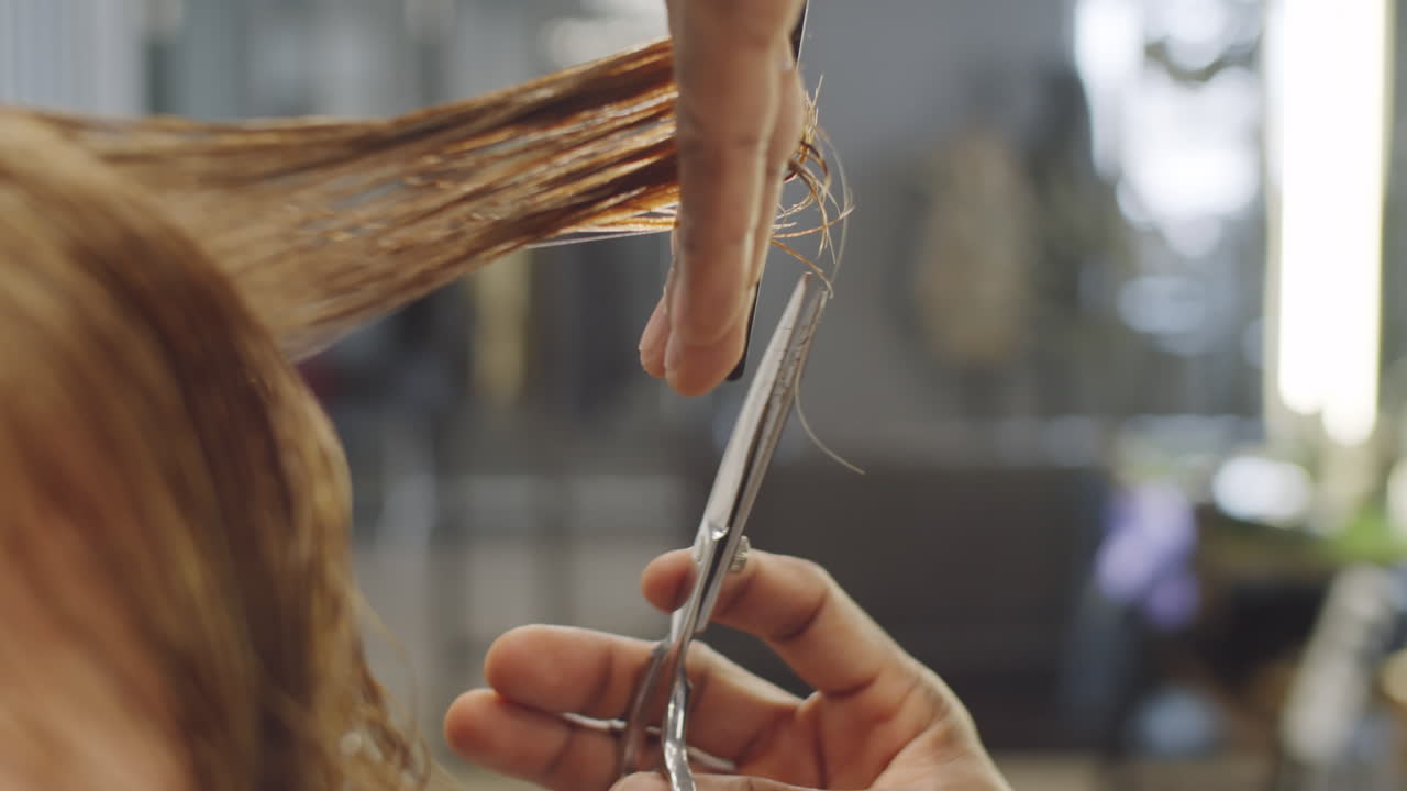 barbero negro con máscara protectora cortando el cabello del cliente