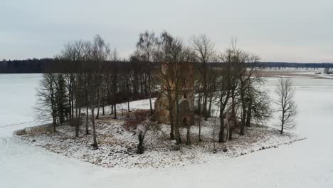 Aerial-view-of-old-abandoned-church-bell-tower-remains-in-snowy-winter