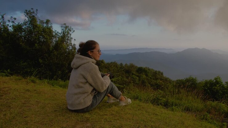 Woman admiring a panoramic mountain view at sunset
