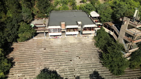 Vista-Aérea-De-Cerca-Del-Edificio-Postcomunista-De-Entretenimiento-Abandonado-Cerca-De-Sofía,-Junto-Al-Lago-Pancherevo