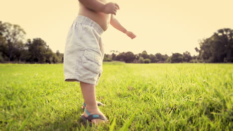 cute baby boy running in grass field