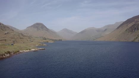 Drone-pull-back-asending-shot-over-Wast-Water-showing-Scarfell-Pike-and-Great-Gable-in-the-Lake-District,-Cumbria