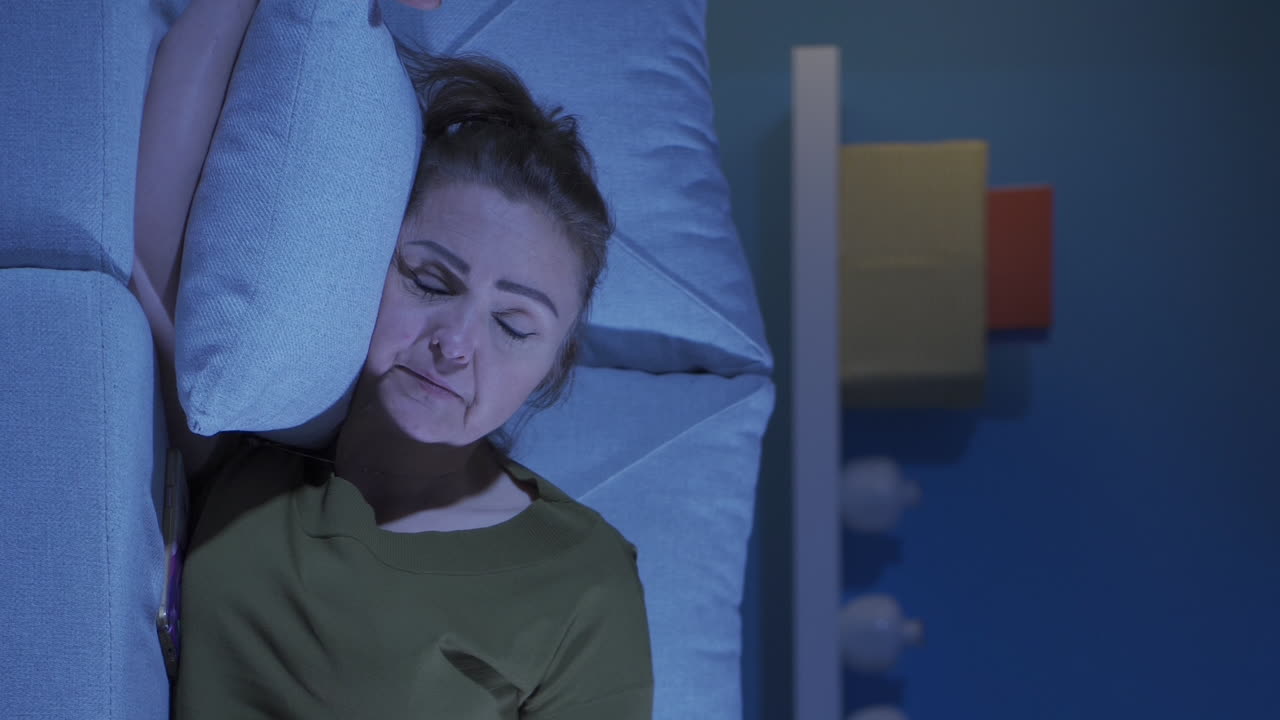 video vertical de una mujer deprimida acostada en el sofá.