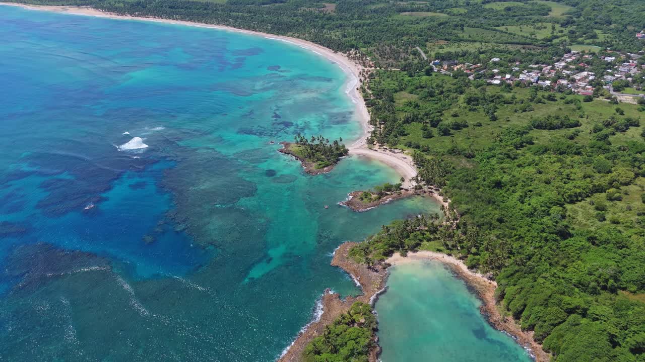 Aerial view tilting backwards over the Playa los Coquitos beach, sunny day in DR