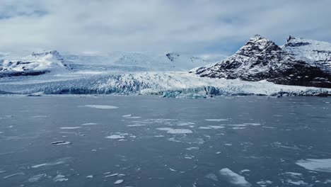 snowy mountains near glacier in volcanic terrain against overcast sky