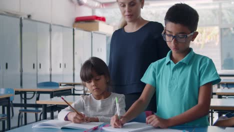 friendly female school teacher watching pupils