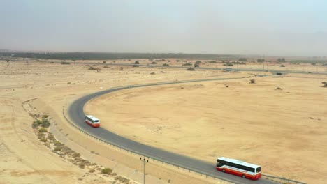 Zwei-Modernen-Touristenbussen-Folgend-In-Die-Wüstenlandschaft