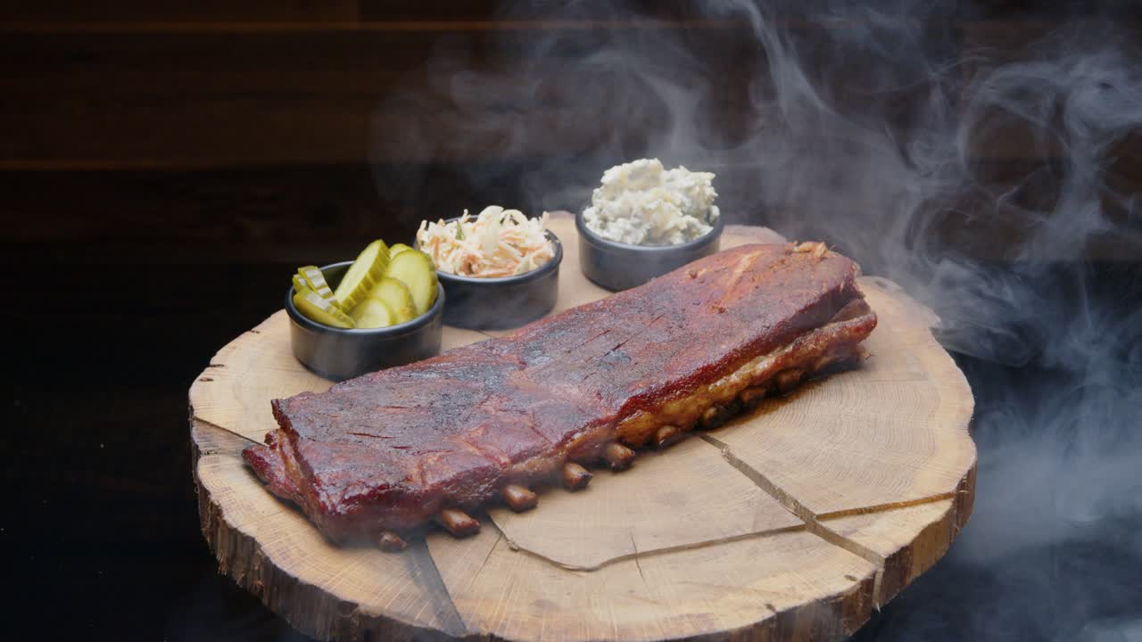 costillas de cerdo perfectamente asadas en un plato rústico de madera con lados cubiertos con una nube de humo