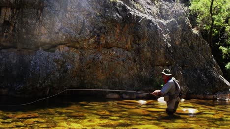 fisherman fly fishing in river