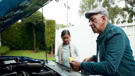 grandfather and granddaughter checking car engine oil