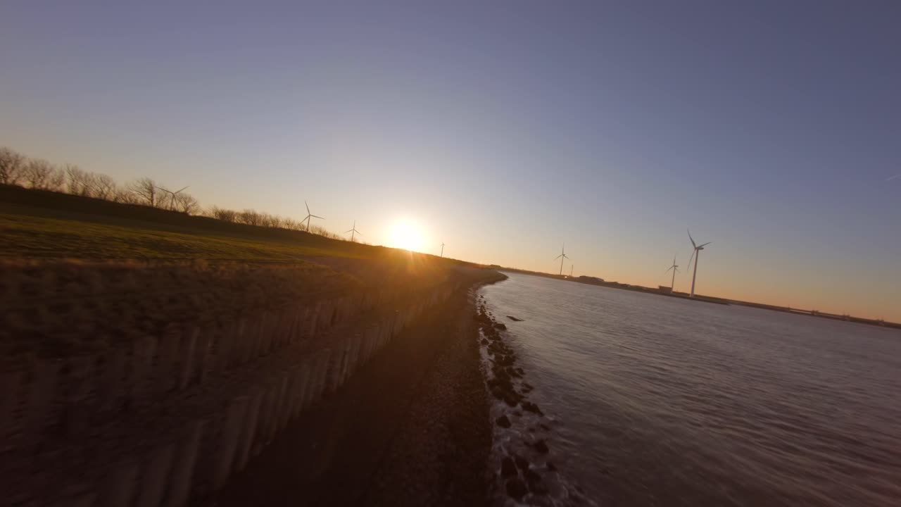 Dutch dyke next to the Delta works during sunset. Fast low angle aerial shot