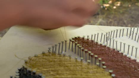 the string art artist is doing the final touches to the art peace and filling the remaining areas with shiny strings