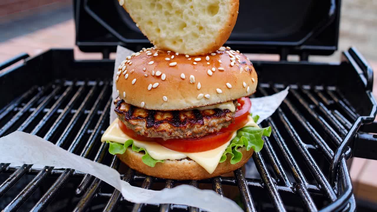 Nærbillede af grillede burgere på en grill, der viser saftige bøffer og friske toppings.