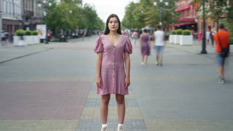 woman in a pink dress on a city street