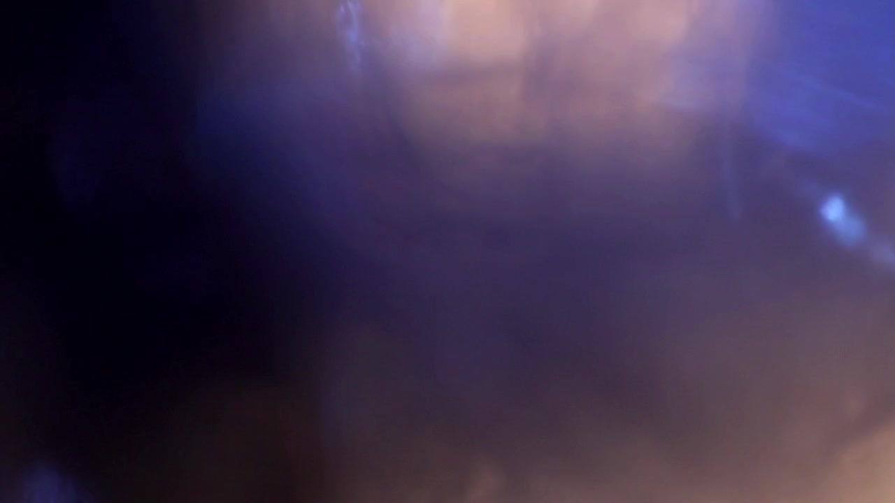Abstract Light Leaks and Lens Flares Transitioning on a Dark Background