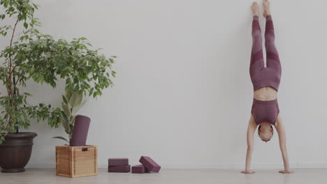 mujer yogi de pie en la postura del árbol mirando hacia abajo