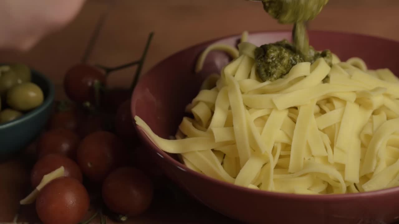 Serving of green pesto sauce and tagliatelle pasta