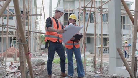 mujer asiática ingeniera civil o arquitecta, inspector con contratista, capataz o trabajador usan casco de seguridad. colegas discutiendo, reuniéndose sobre el proyecto de construcción en el sitio.
