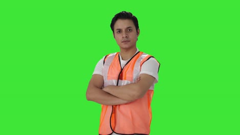 portrait of indian airport staff worker standing crossed hands green screen