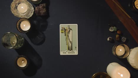 Overhead-Shot-Of-Person-Giving-Tarot-Card-Reading-Laying-Down-The-Hermit,-The-King-Of-Swords-And-The-Hanged-Man-Cards-On-Table