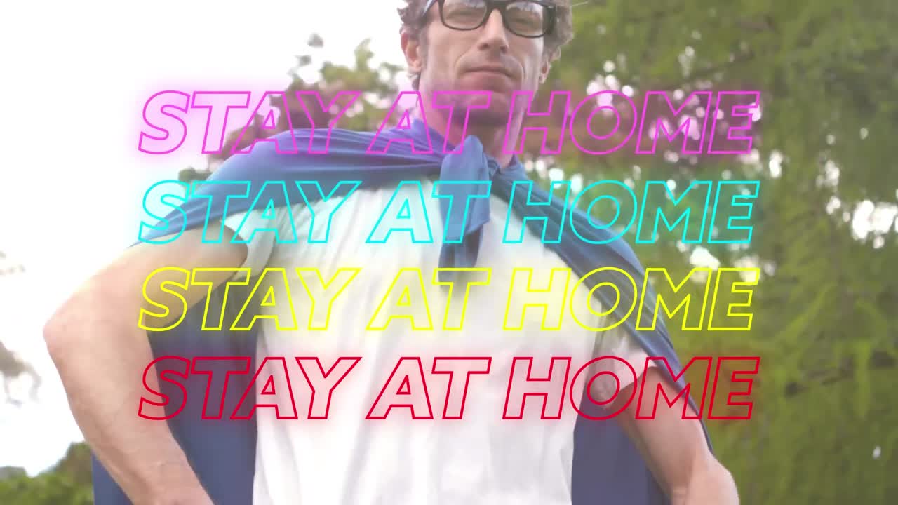 animación de cuatro líneas de texto de neón quedarse en casa sobre un hombre caucásico que lleva una capa