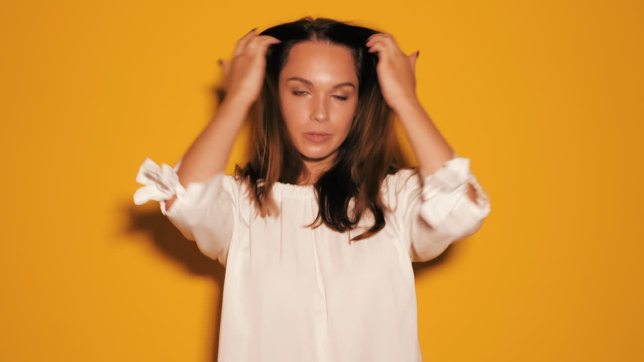 여성이 스튜디오에서 미소 짓고 포즈를 취하고 있습니다.