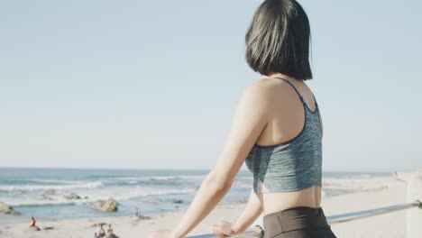 happy biracial woman stretching on promenade, in slow motion