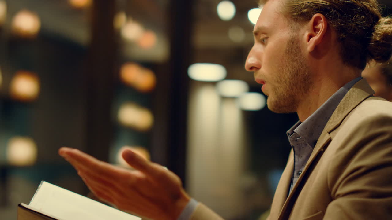 jefe guapo buscando libro de planificación en la oficina. hombre de negocios reuniéndose con los empleados
