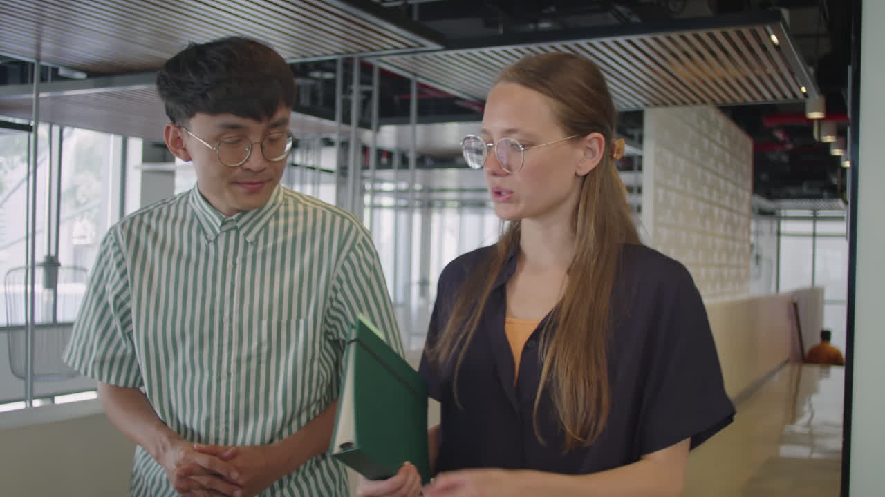 Young Multi-Ethnic Colleagues Walking in Office and Talking