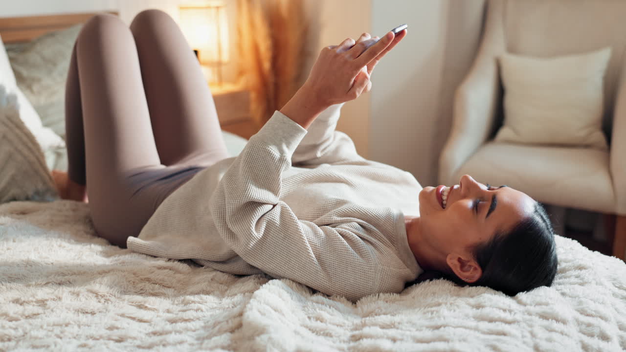 스마트폰으로 침대에서 휴식을 취하는 여자