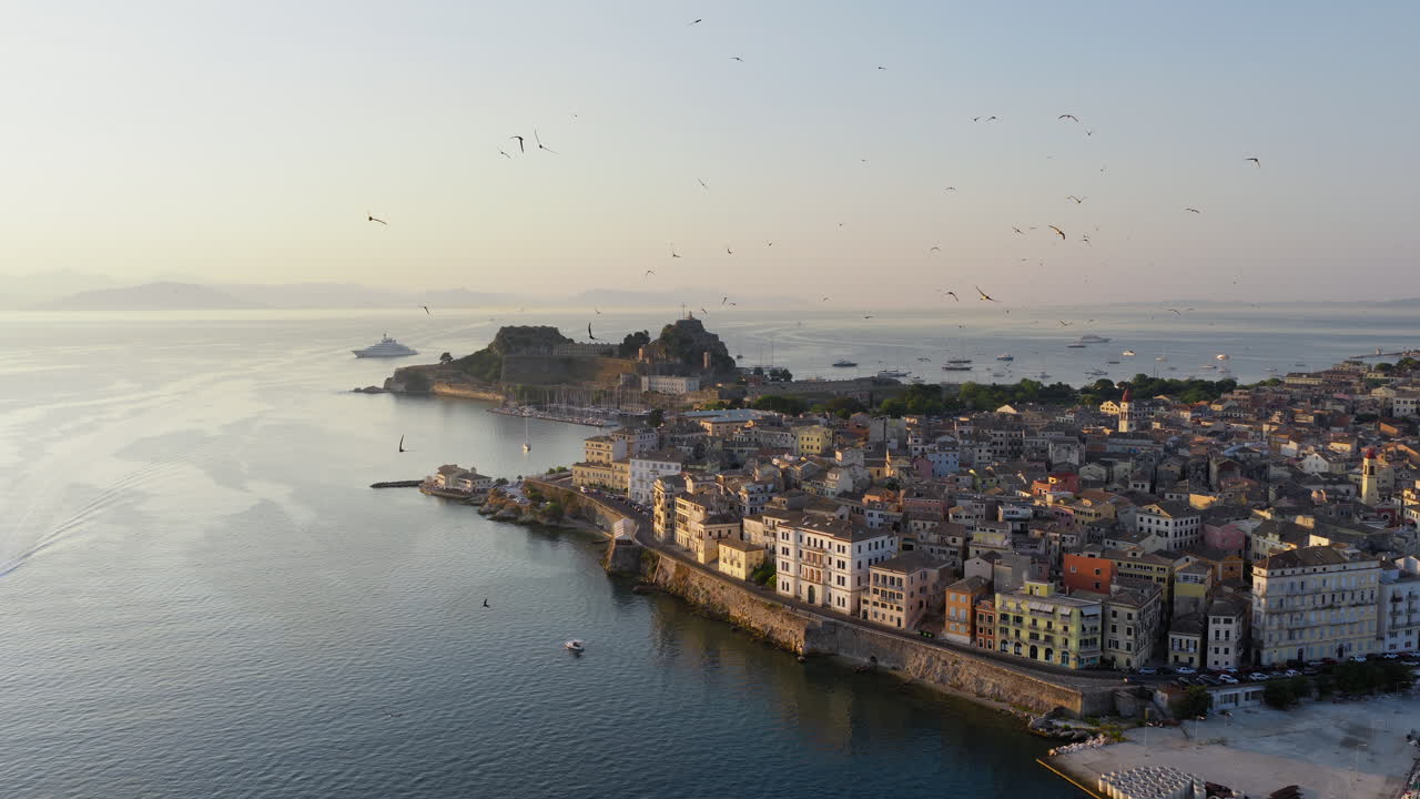 Corfu Old Fortress and rooftops during sunrise with early golden light from the sea