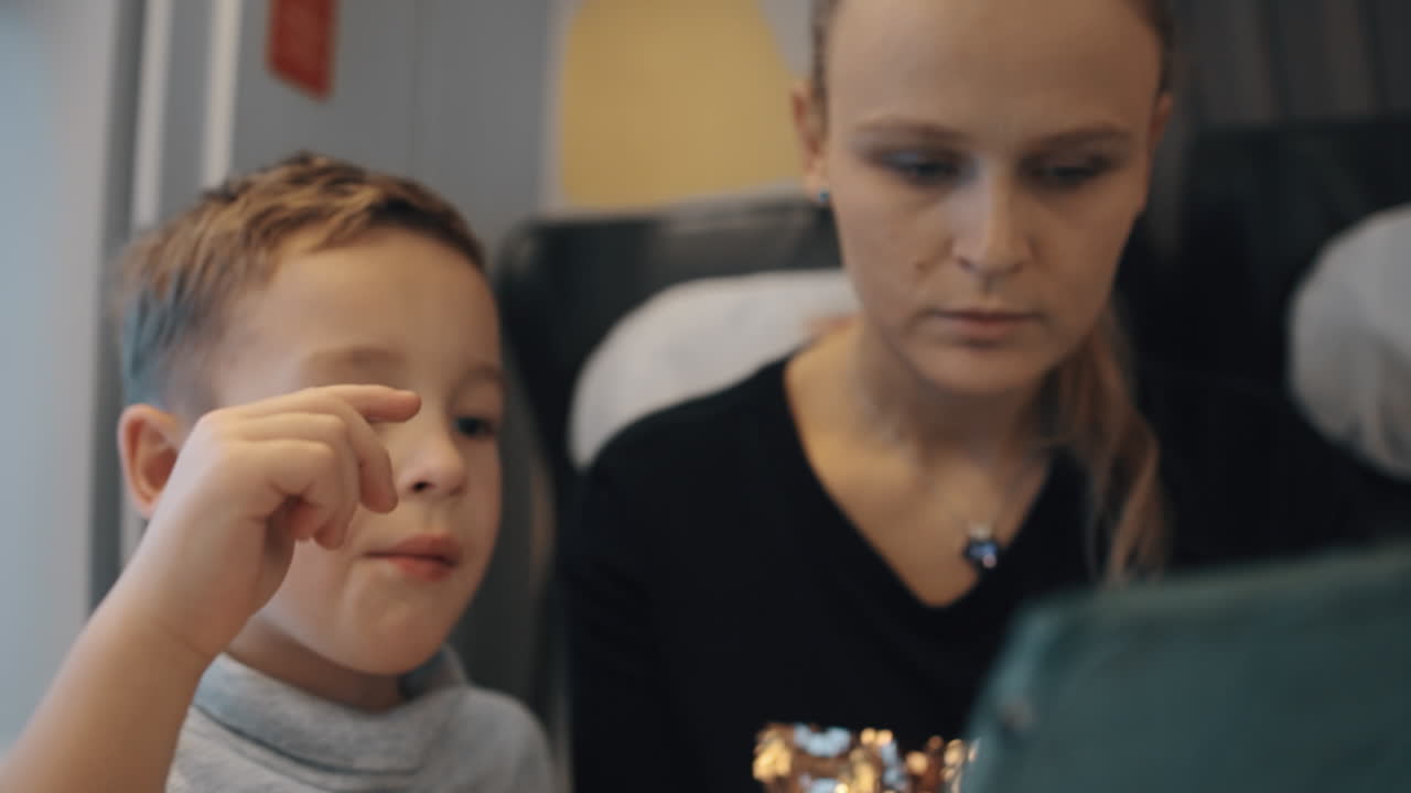 los juegos en la tableta digital les ayudan a pasar el tiempo durante el viaje